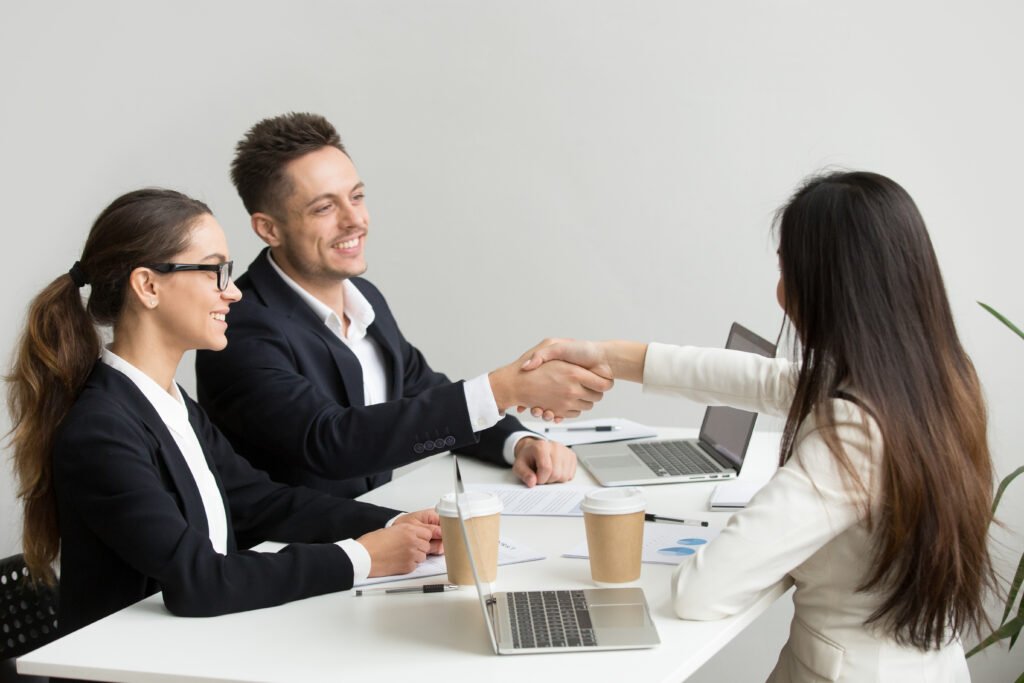 friendly partners handshaking group meeting thanking successful teamwork