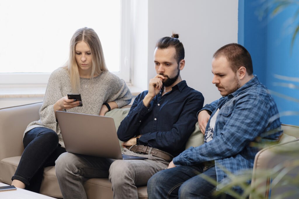 team three people working laptop office sofa